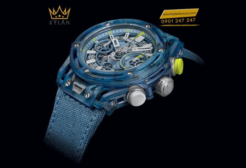 Mặt số xanh mờ với kim vàng tennis ball và logo Djokovic trên rô-tơ, dây Velcro thể thao.