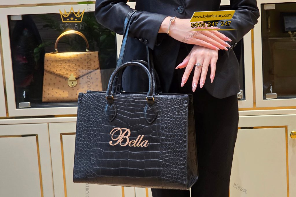 Túi xách nữ full da cá Alligator black đính logo chữ Bella vàng Au750