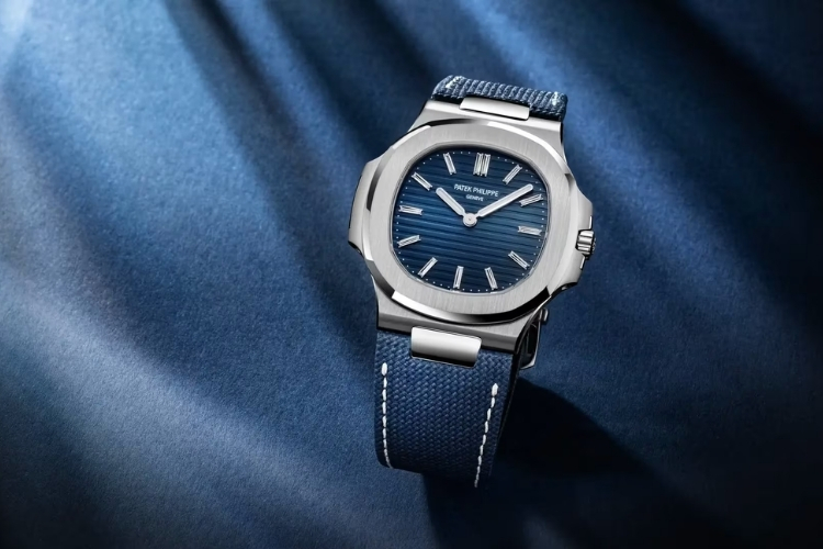 Mặt số xanh sunburst dập ngang kết hợp cọc số kim cương baguette tạo điểm nhấn cao cấp.